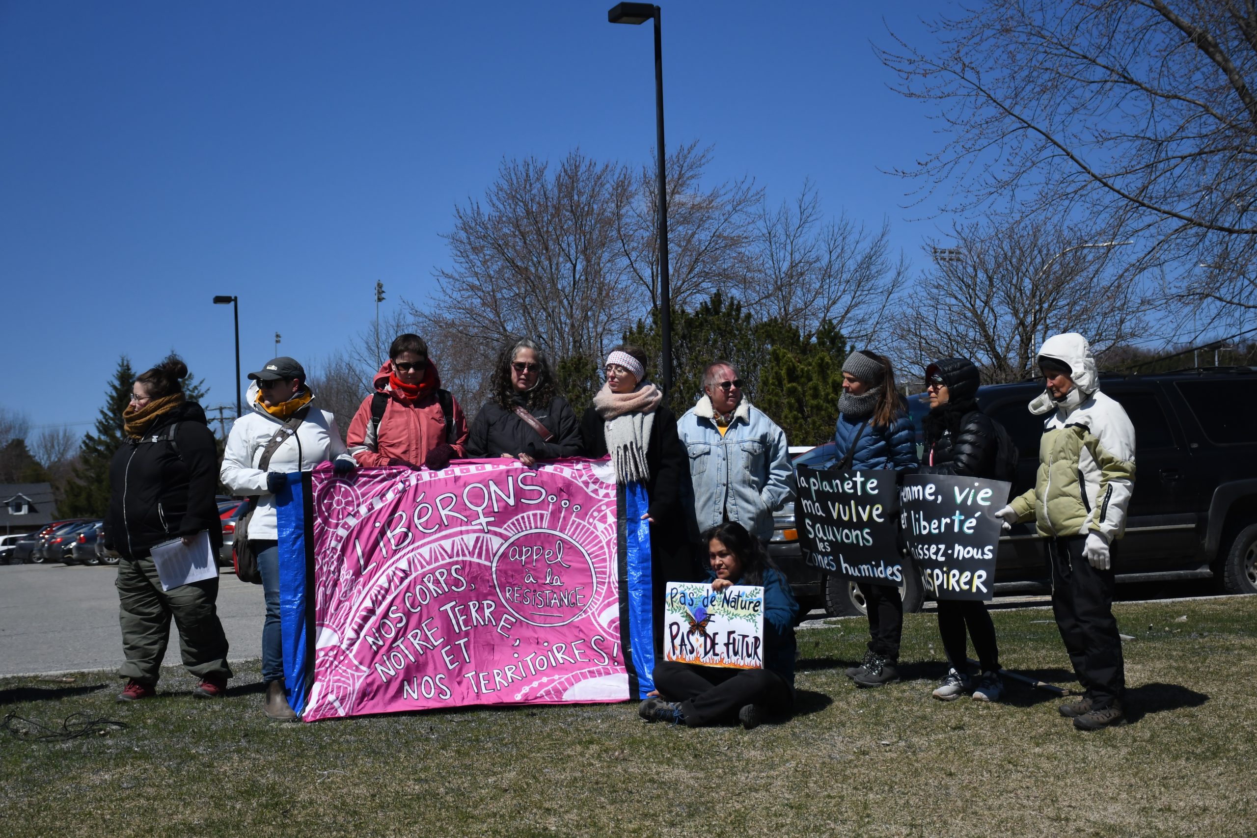 Le contingent de la Marche Mondiale des Femmes tient une bannière lors du discours d'ouverture.